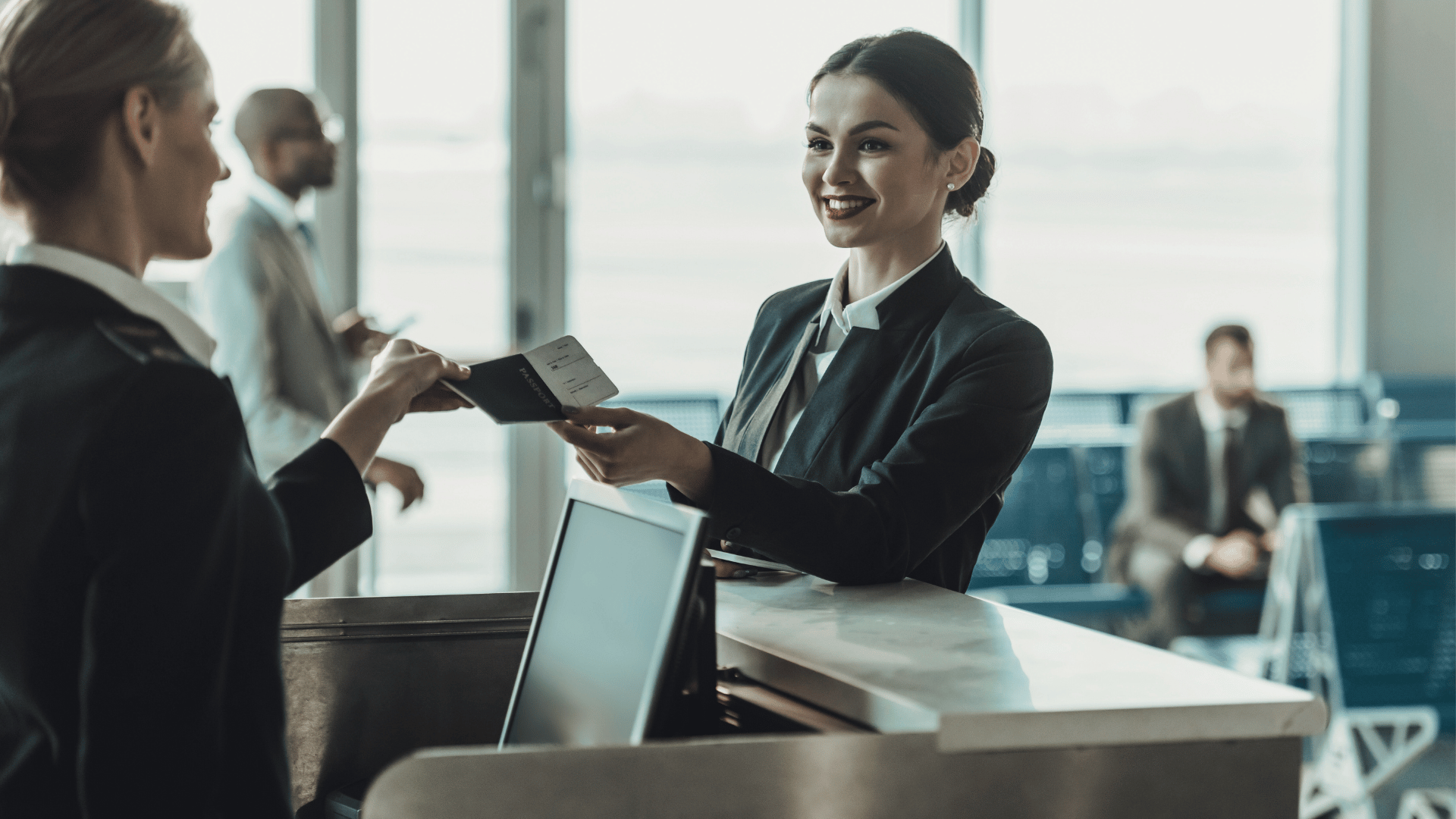 Two airport staff checking a boarding pass.