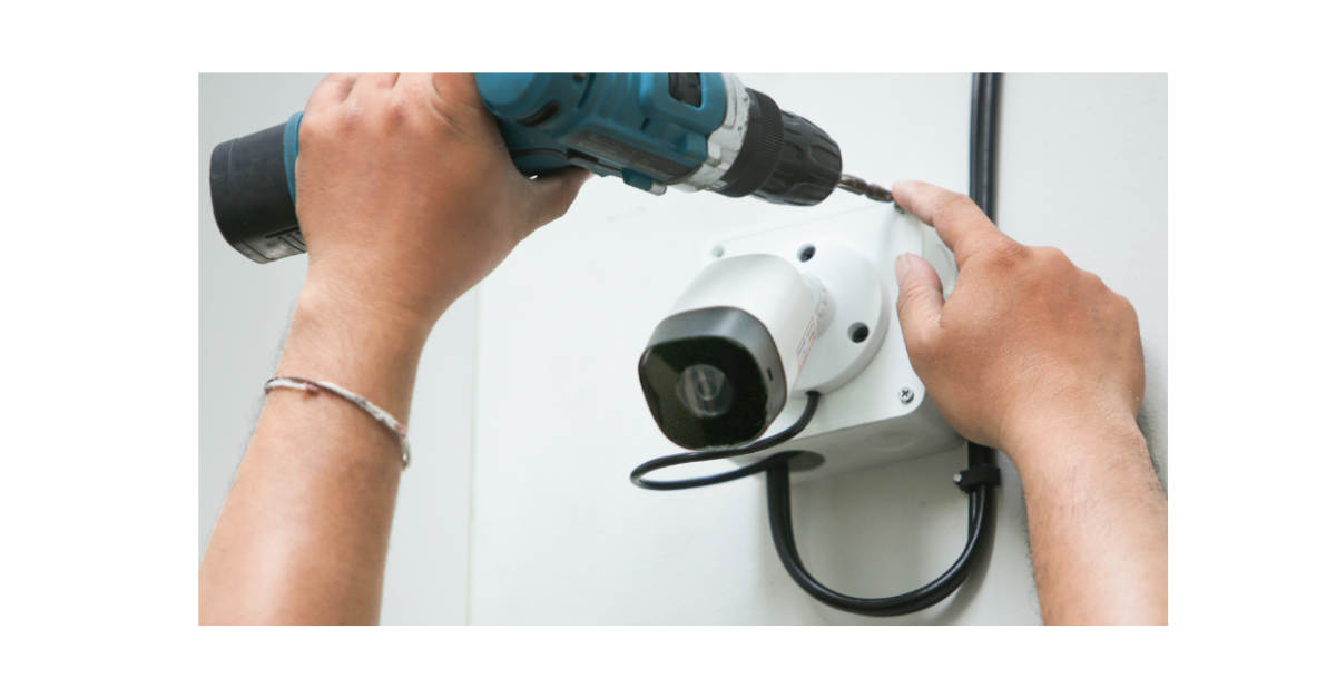 Someone is drilling a CCTV camera to a wall.