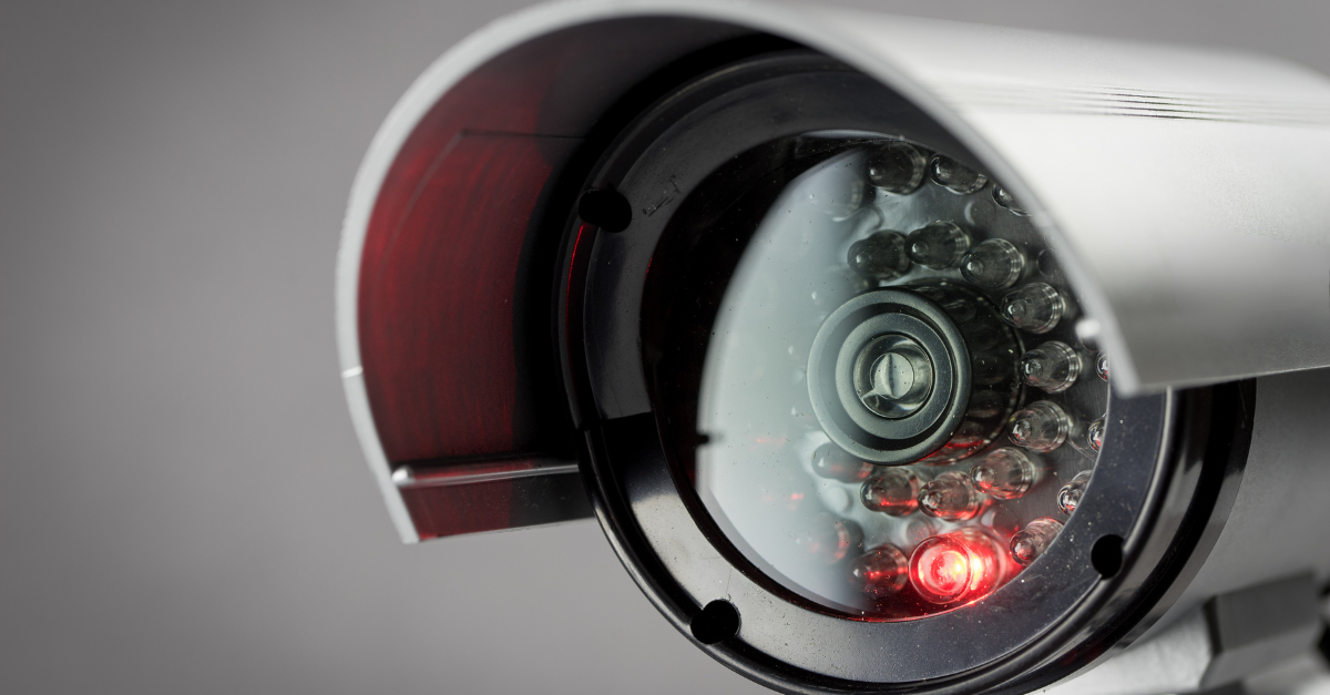 A close up of a security camera with a red light to show it is recording.