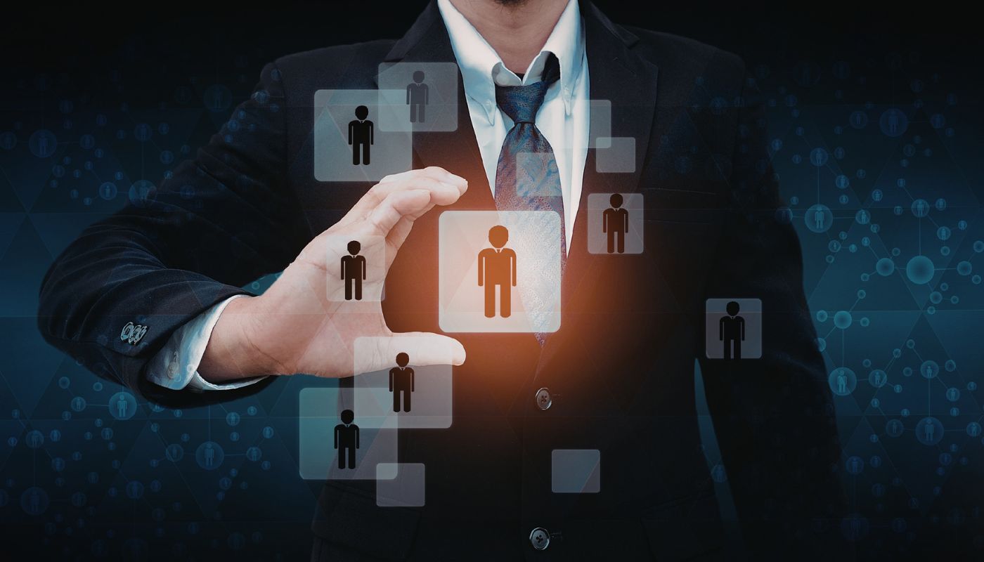 A business man is looking and about to hold a digital symbol of people.