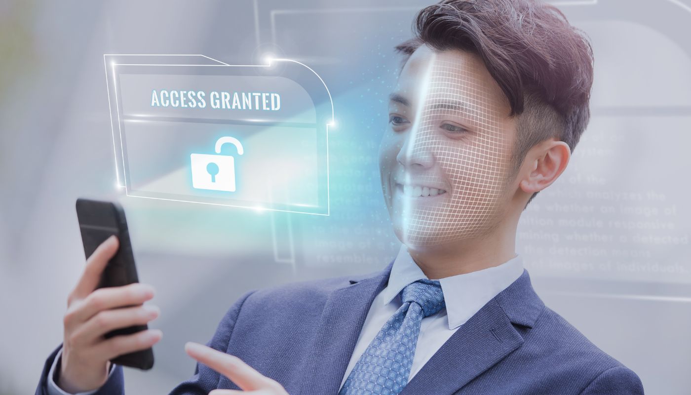 Someone has a phone scanning there face, it says access granted with a padlock open.
