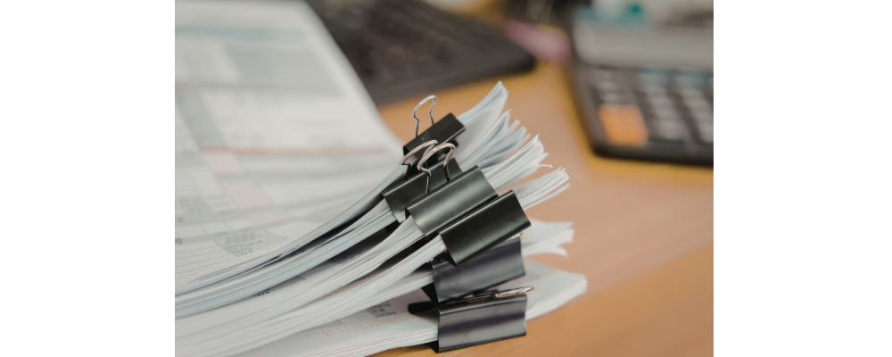 A stack of paper separated into groups with bull dog clips.