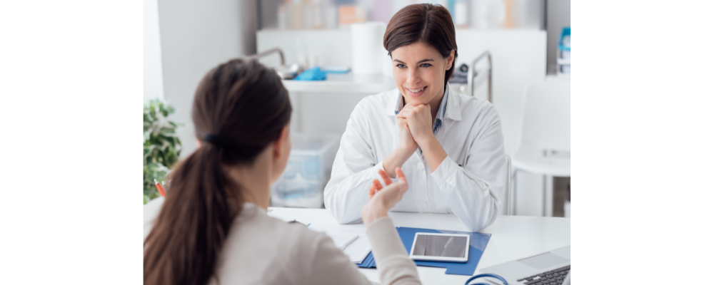A nurse is speaking to a customer in a medical room.