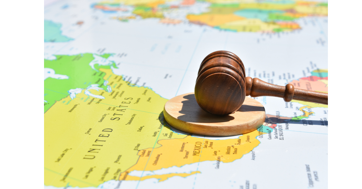 There is a world map with a gavel and block on top of it.