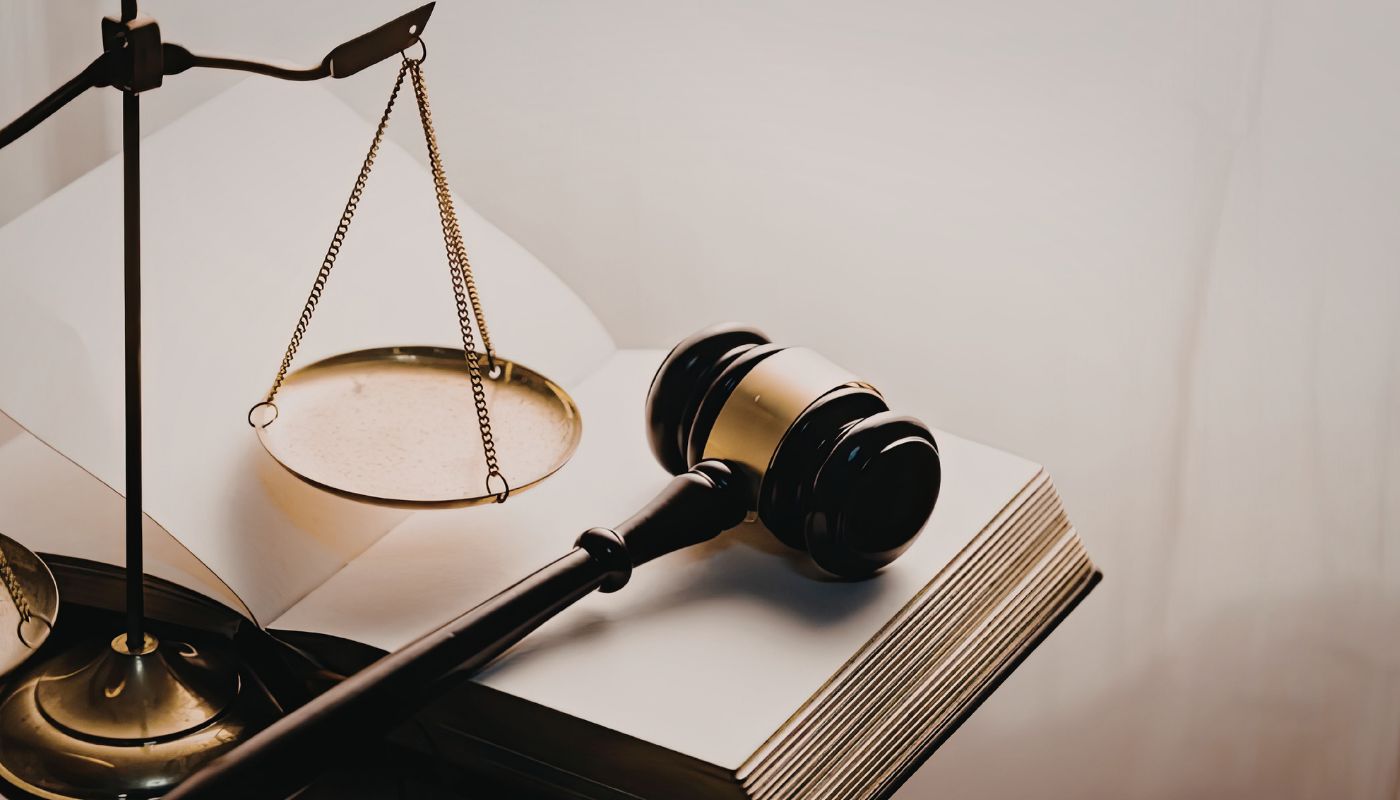 A gavel and weight is on top of an open book.