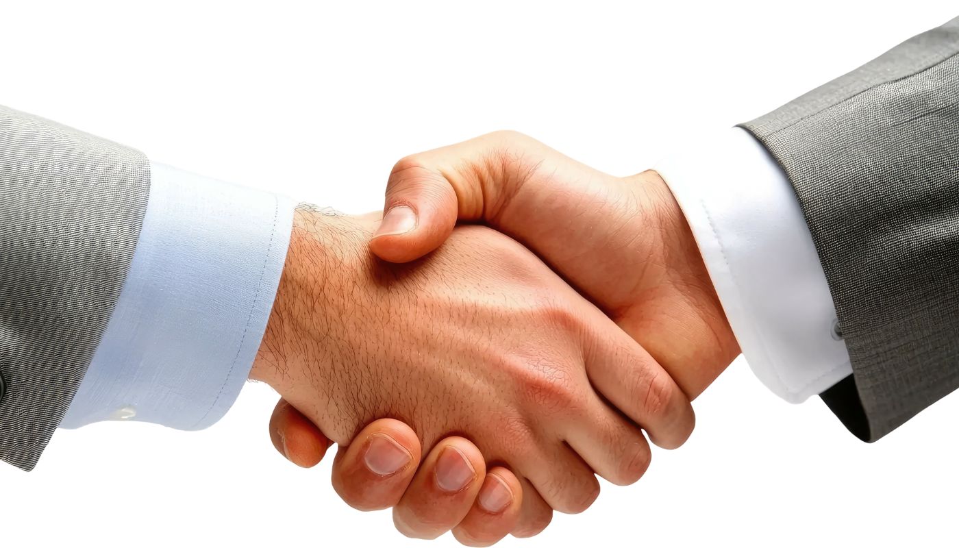 A close up of two men in suits hand shaking.