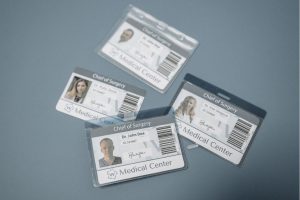 Four ID cards on a table in card holders for a medical centre.