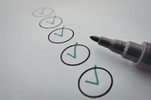 There is a long line of circles on a page with ticks inside the circles and a marker pen next to the checklist.