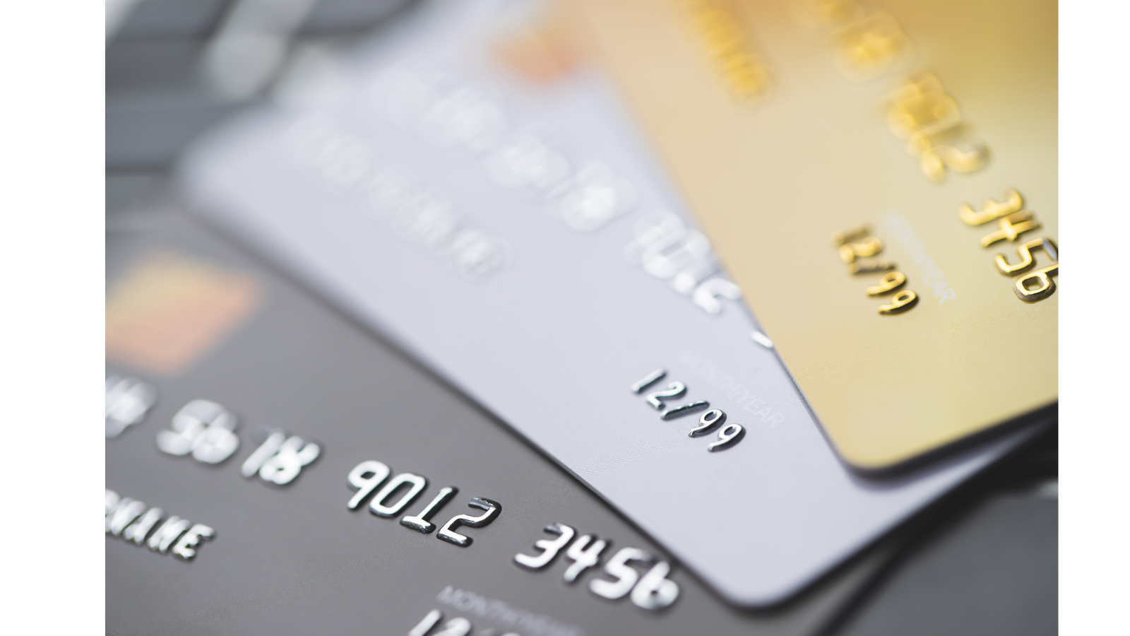 Multiple different coloured bank cards stacked on top of each other.