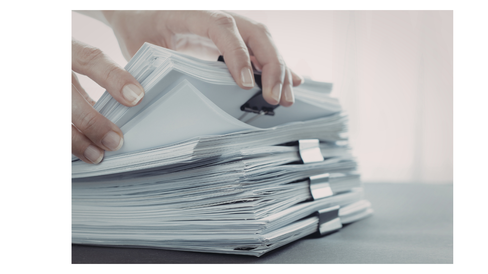 A large stack of paper separated by bull dog clips.