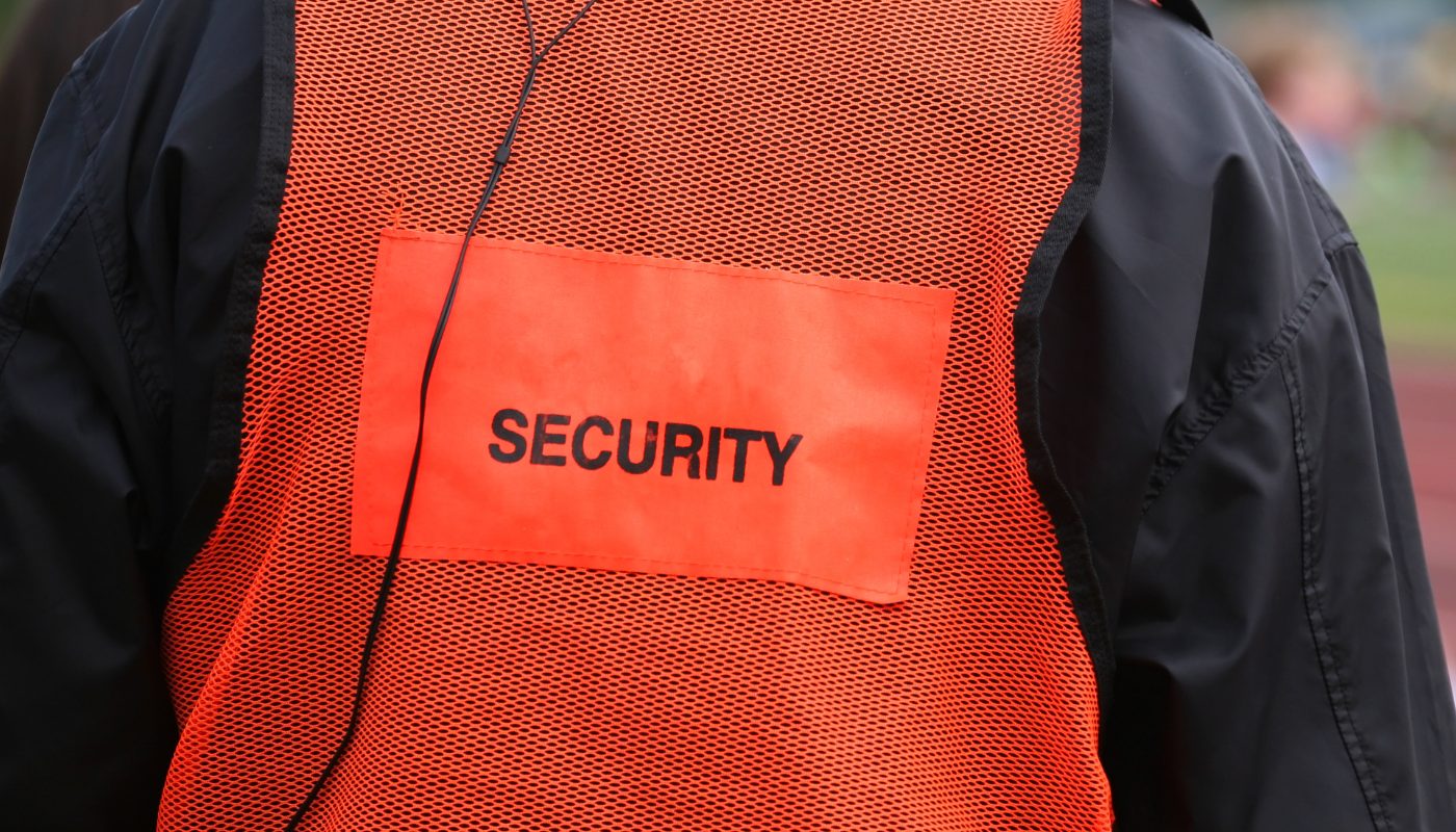 A close up of an orange hi-vis that says security on it.