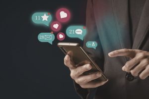 There is a business man on a phone with like, follow, comment icons around it.