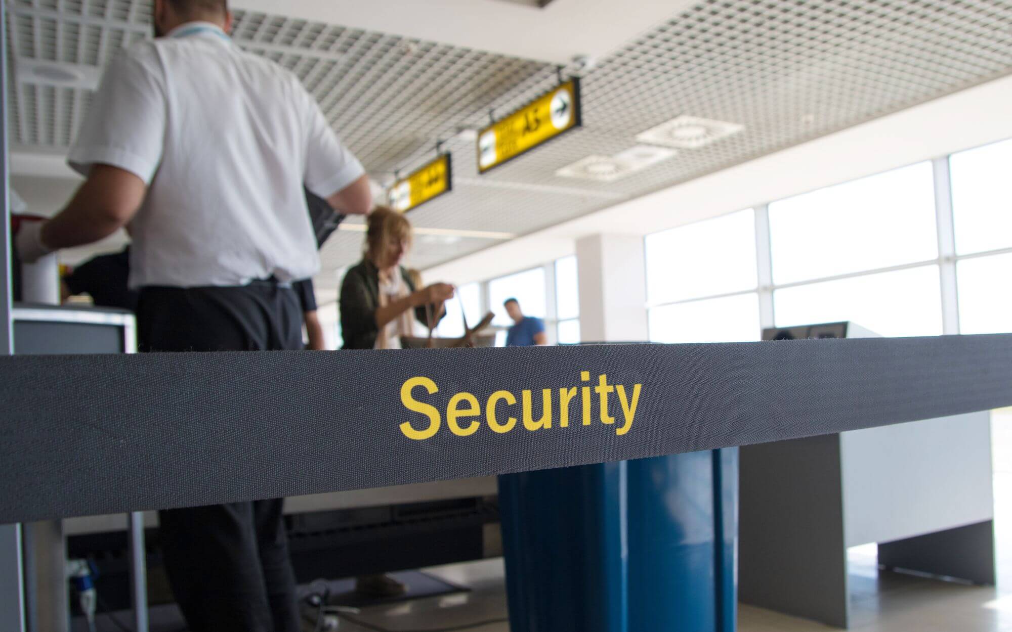 A barrier with security written across it in an airport.
