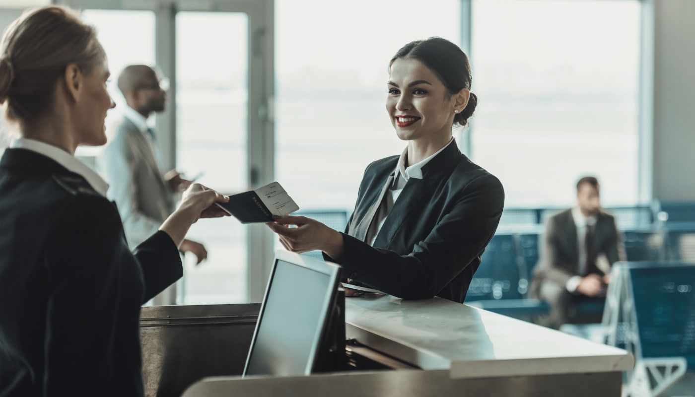 Two airport staff checking a boarding pass.