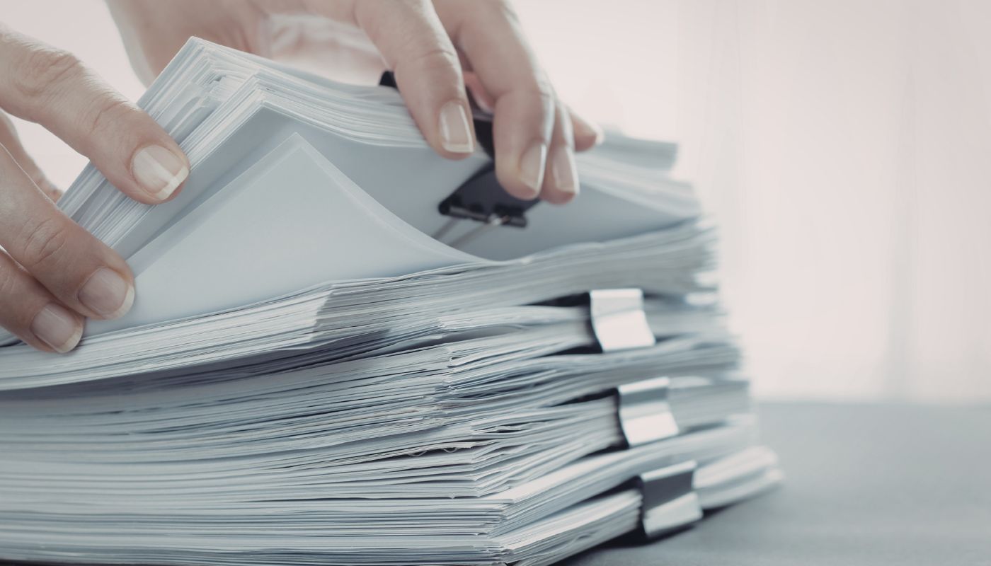 A large stack of paper separated by bull dog clips.