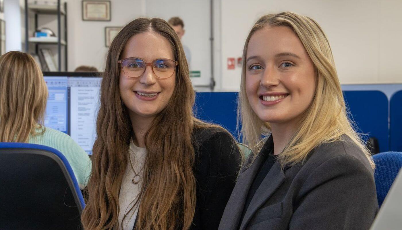 Two staff members at Security & Vetting Solutions smiling in the office.