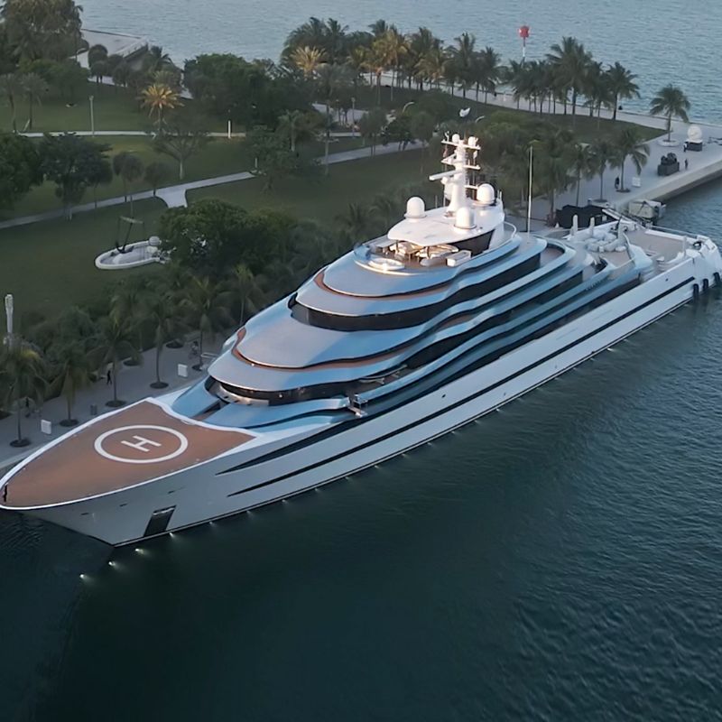 A huge yacht sailing through the sea near an island.